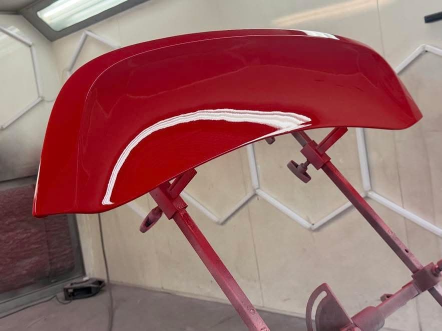 Glossy red painted bumper in the spray booth