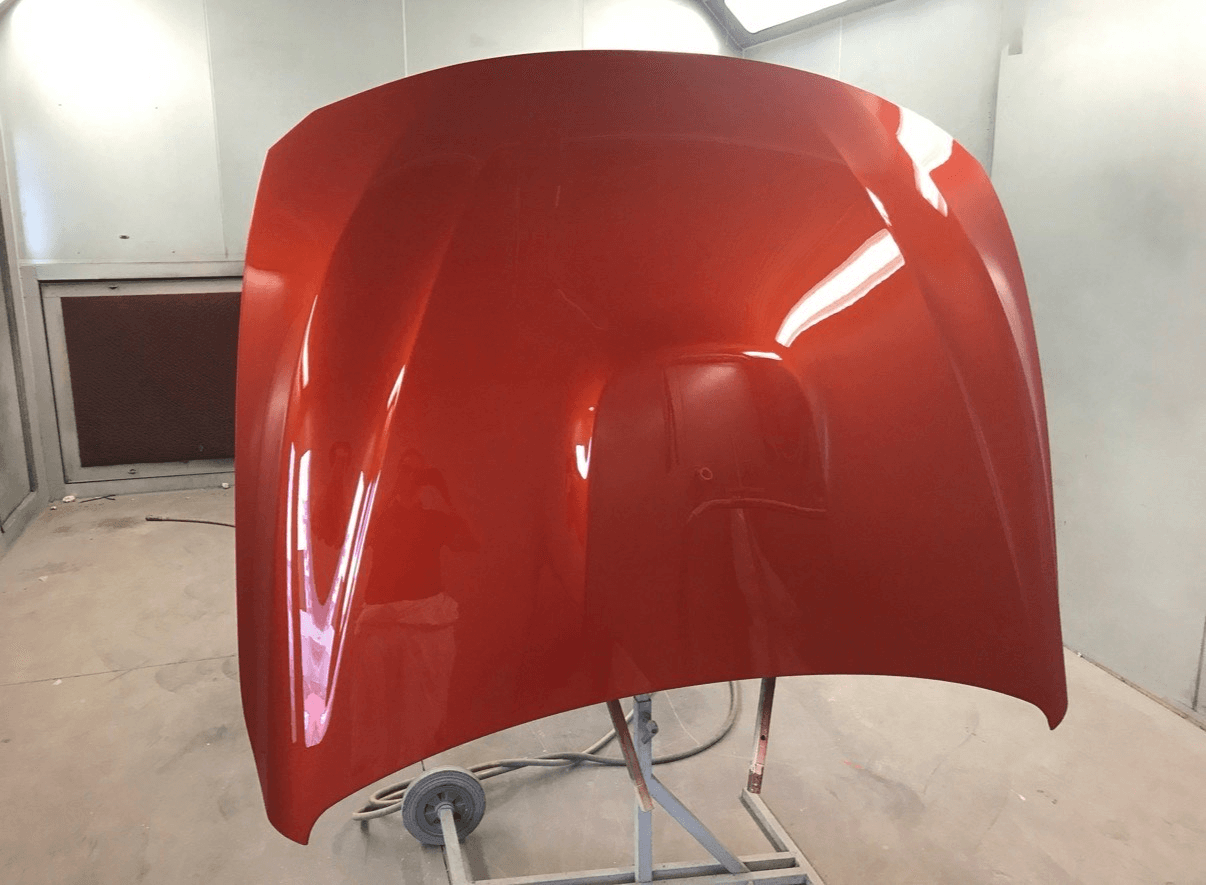 Glossy red painted bonnet in the spray booth
