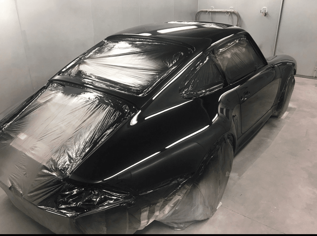 Black classic sports car masked after refinishing