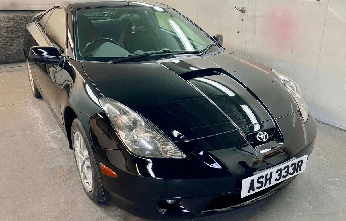 Black Toyota coupe after refinishing in the spray booth