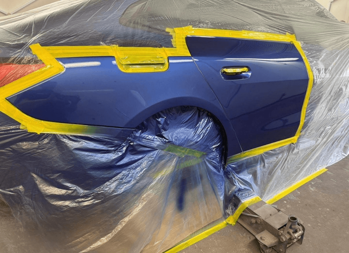Blue vehicle side panel during a respray